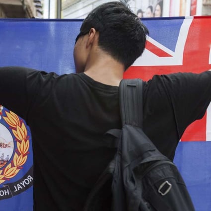 A pro-independence protester holds up a flag that recalls British colonial days during the annual July 1 rally in the city. Photo: EPA
