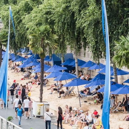 Tourists and Parisians enjoy sunbathing at an artificial beach on a Paris Plage area along the bank of the river Seine in Paris, France. Photo: EPA