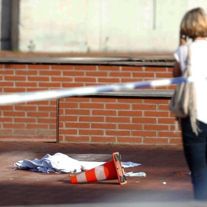 A woman stands at the site where a machete-wielding man injured two female police officers before being shot outside the main police station in Charleroi, Belgium. Photo: Reuters