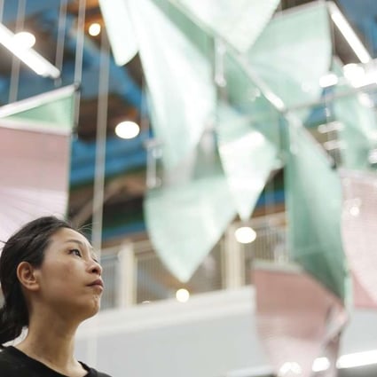 South Korean artist Haegue Yang poses under her installation Lingering Nous at the Centre Pompidou. The monumental artwork is an assembly of colourful Venetian blinds. Photo: AFP