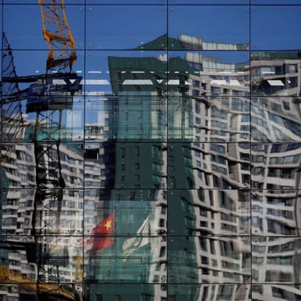 A construction site and a residential building are reflected in the glass wall of a building in Beijing. To fully understand China, one must first understand the rest of the world. Photo: Reuters