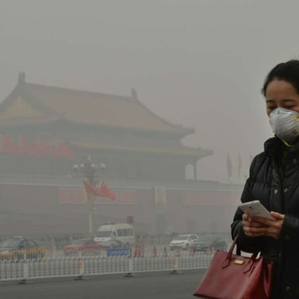 A woman walks beside Tiananmen Square as heavy air pollution shrouds Beijing. Photo: AFP