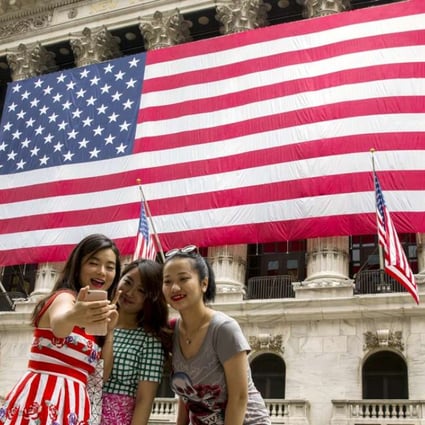 Chinese tourists outside the New York Stock Exchange. Spending on travel has become a priority for many of the country’s younger generation, according to a new HSBC survey. Photo: Reuters