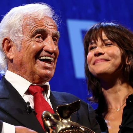 Actor Jean-Paul Belmondo smiles as he receives a Golden Lion award for lifetime achievement presented by French actress Sophie Marceau at the 73rd Venice Film Festival. Photo: Reuters