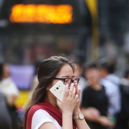 A woman covers her mouth at a crossing in Causeway Bay. Photo: Sam Tsang