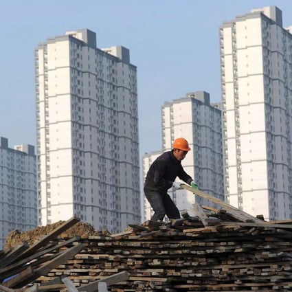 A construction worker selects wooden planks at a residential site in Hefei. Photo: Reuters