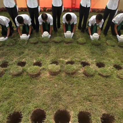Young Chinese soldiers perform burial duties of 280 biodegradable urns during a collective eco-burial ceremony at the cemetery of Tianjin on July 20, 2010. The patented urns in China, are designed to contribute to the protection of the environment as space at cemeteries has become a serious issue in a country which has 1/5 of the world's population and has a death rate of up to 10 million a year. Photo: Imagechina