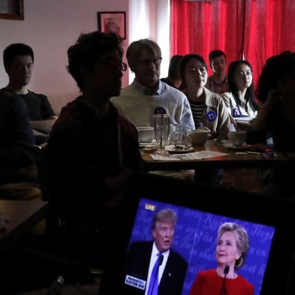 People watch live broadcasting of the U.S. presidential debate between Democratic presidential nominee Hillary Clinton and Republican presidential nominee Donald Trump, at a cafe in Beijing, Tuesday, Sept. 27, 2016. (AP Photo/Andy Wong)