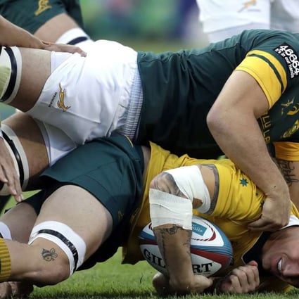 Australia’s Sean McMahon is tackled by South Africa’s Francois Louw. Photo: AP