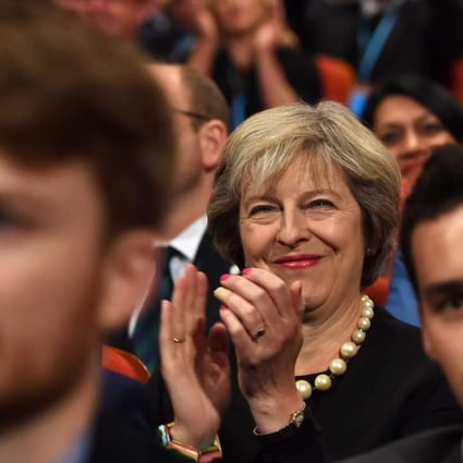 British Prime Minister Theresa May smiles as she listens to delegates during the Conservative Party conference in Birmingham. Photo: EPA