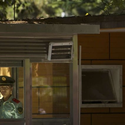 A Chinese paramilitary policeman talks on the telephone at a guard booth outside the North Korean embassy in Beijing. File photo: AP