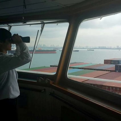 A crew member looks out from the deck of a ship in Singapore. Photo: Reuters