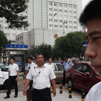 Chinese men in plain clothes, believed to be security personnel, follow journalists outside a Tainjin court sentencing human rights lawyer Zhou Shifeng in August. Photo: EPA