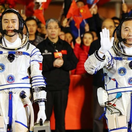 Chinese astronauts Jing Haipeng, right, and Chen Dong wave during a farewell ceremony before embarking for the launch of the Shenzhou-11 spacecraft at the Jiuquan Satellite Launch Centre in Gansu province. Photo: EPA