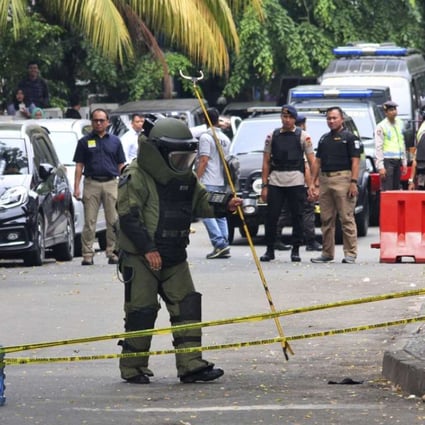 A member of police bomb squad inspects the site where police officers were attacked earlier, in Tangerang, Indonesia. A man with an Islamic State group symbol was shot Thursday after attacking the officers with a machete, police said. Photo: AP