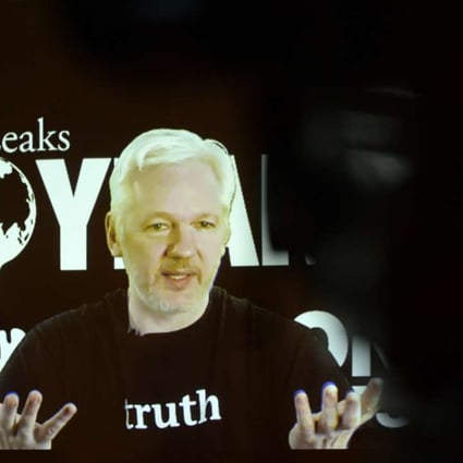 WikiLeaks founder Julian Assange speaks via video link at an event in Berlin on October 4. Assange says a company with Clinton ties is attempting to smear him. Photo: TNS