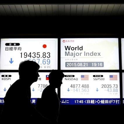 People walk past an electronic board displaying various Asian countries' stock price index and world major index outside a brokerage in Tokyo, Japan. Photo: Reuters