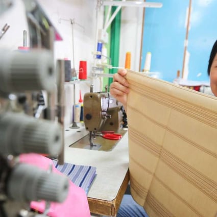 Seamstress Huang Fengteng displayes her handiwork . Photo: Felix Wong