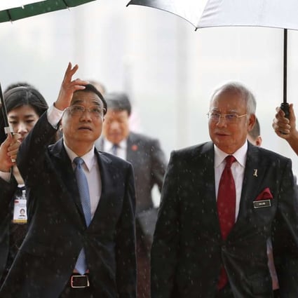 Chinese Premier Li Keqiang takes shelter from the rain with Malaysian Prime Minister Najib Razak after inspecting a guard of honor in Putrajaya, Malaysia in 2015. Photo: AP