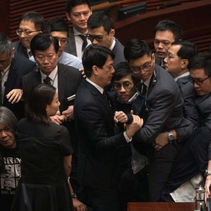 Security guards try to remove legislator-elect Sixtus Leung (centre) from the Legislative Council chamber as pan-democrats create a protective ring around him on November 2. The chaos in the aftermath of the oaths controversy has caused much damage to Hong Kong society. Photo: EPA