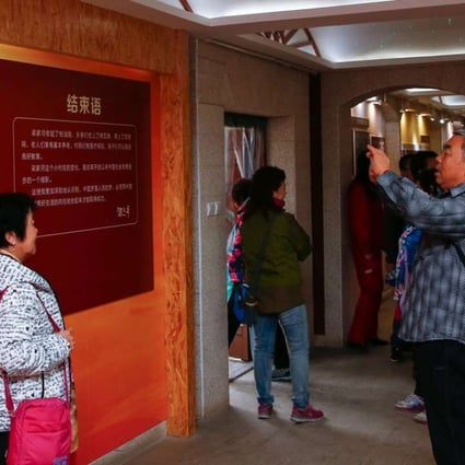 Visitors pose for photos in front of an image of President Xi Jinping at a museum in the village where Xi lived as a youth, in Liangjiahe, Shaanxi province. Photo: AFP