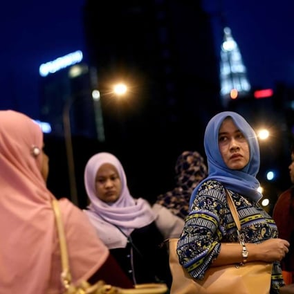 Malaysian women return from work in Kuala Lumpur. Malaysian PM Najib Razak has secured deals with China worth deals worth RM144 billion to the Malaysian economy. Photo: AFP