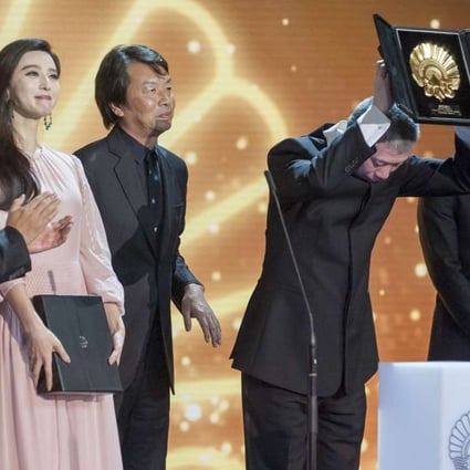 Feng Xiaogang holding aloft his "Concha de Oro" (Golden Shell) award for the film I am not Madame Bovary beside the Silver Shell Best Actress winner Fan Bingbing during the 64th San Sebastian International Film Festival in September. Photo: AFP