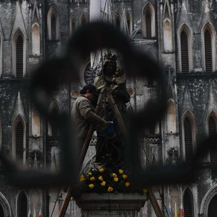 A worker polishes a statue at Hanoi’s cathedral. Hanoi recognises 39 religious organisations within 14 religions. Photo: AFP