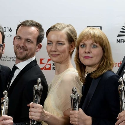 Toni Erdmann’s writer-director Marin Ade (centre), stars Sandra Hueller (second from right) and Peter Simonischek (right), and producers pose with the awards the film received at the European Film Awards. Photo: AFP