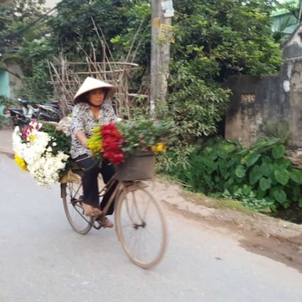 A vendor carries flowers to the market on her bicycle. Photo: Karim Raslan
