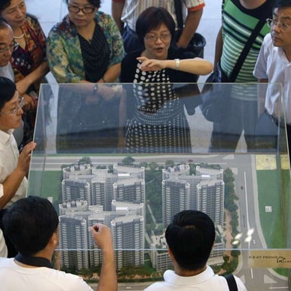 Explaining how it’s done: A group of visitors from China listen as their guide speaks about Singapore’s public housing policy. Photo: Reuters