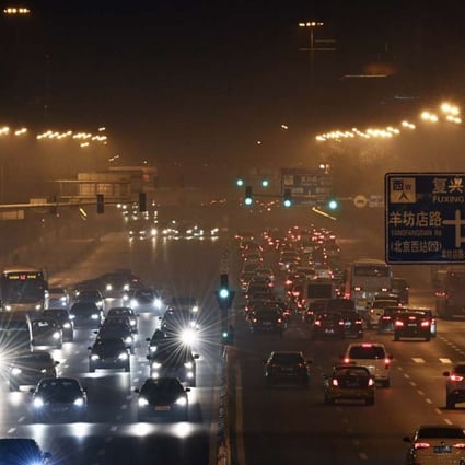 Cars move on a road blanketed in smog in Beijing on Friday, when the capital city activated its first red alert for air pollution this year. Photo: Xinhua