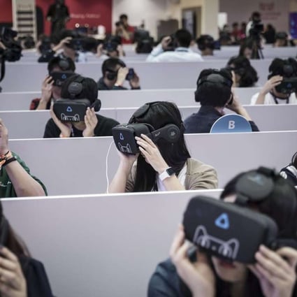 Members of the media wear virtual reality headsets featuring the Tmall Cat, mascot for Alibaba Group Holding Ltd.'s Tmall online marketplace, at Alibaba's annual November 11 Singles' Day online shopping event in Shenzhen. Photo: Bloomberg