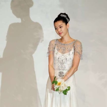 Blushing bride Gianna Jun in a drapery white dress embellished with sparkling crystal oozes femininity on her big day.