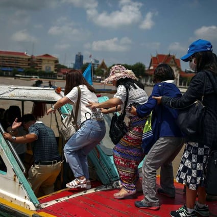 Chinese tourists board a sightseeing boat on the Chao Phraya River in Bangkok. Photo: Reuters