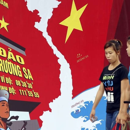 Two women pass a board featuring a map of Vietnam and the words 'Spratly Islands' in a street in Hanoi, Vietnam. Diplomatic disputes between China and Vietnam have prompted resentment of Chinese tourists in the country. Photo: EPA