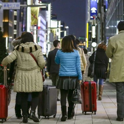 Chinese tourists carry suitcases packed with purchases after bulk buying, or ‘Bakugai’ in central Tokyo. Chinese tourists' shopping makes a large contribution to the Japanese economy. Photo: EPA