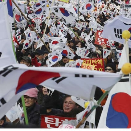Supporters of South Korean President Park Geun-hye wave their national flags during a rally opposing her impeachment in Seoul. Photo: AP