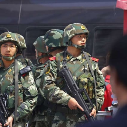 A file picture of paramilitary policemen standing guard at a railway station in Urumqi in Xinjiang. Photo: Reuters