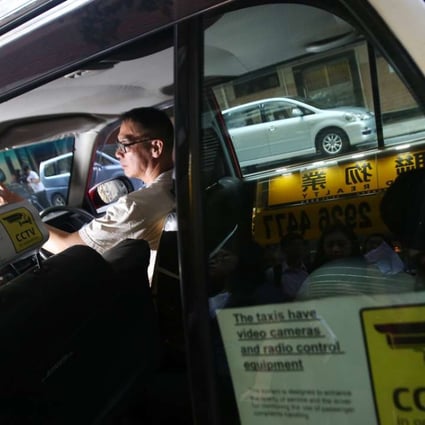 A rear window sticker declares the presence of closed-circuit TV cameras and radio equipment in a taxi in Ho Man Tin last September. The Association of Taxi Industry Development says it aims to raise service quality with the installation of on-board surveillance cameras. Photo: David Wong