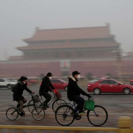 People wear masks to protect themselves from the smog as they cycle in Beijing. Photo: Reuters