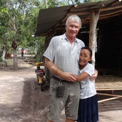 Chantrea, who had a meningoencephalocele (MEC), was trafficked as a beggar before being spotted by Jock Struthers at Cambodia’s border with Vietnam, in 2012. She is seen here with Struthers, in June 2016, at her family’s home. Pictures: courtesy of Jock Struthers and the Children’s Surgical Centre