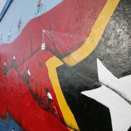 A Timorese youth makes finishing touches on a mural in Dili, East Timor. Photo: AP