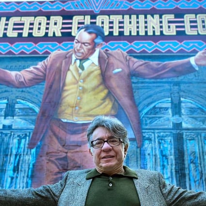Muralist Eloy Torres mimicks the pose of Oscar-winning Actor Anthony Quinn on the 70-foot-tall "Pope of Broadway" mural he helped restore after years of deterioration during a ceremony in downtown Los Angeles. Photo: AFP