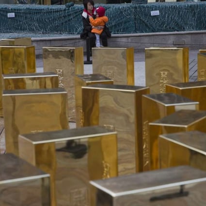 China’s gold appetite surged in 2016 as the yuan softened against global currencies. Replica gold bars are displayed at a mall in Beijing. Photo: AP