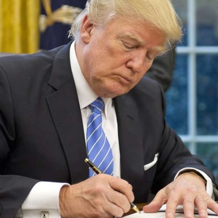 US President Donald Trump signs an executive order in the Oval Office of the White House in Washington. Photo: EPA