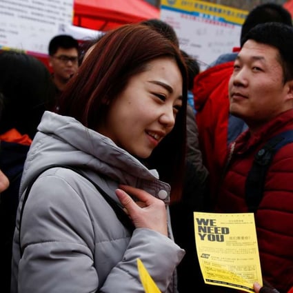 A recruiter hands out a flyer at an employment fair for college graduates in Shijiazhuang, Hebei province. Photo: Reuters
