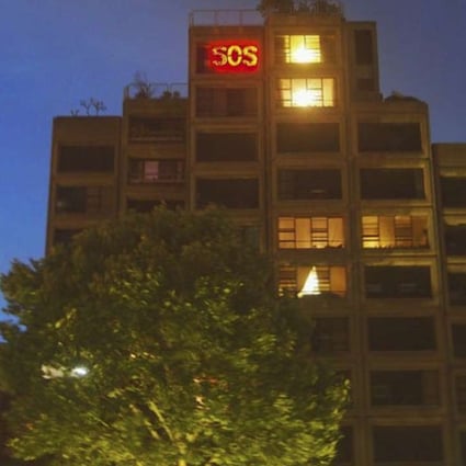 An SOS sign lights up in the window of the home of 90-year-old Myra Demetriou, one of two remaining residents of the Sirius building in Sydney’s Millers Point. Photo: John Dunn
