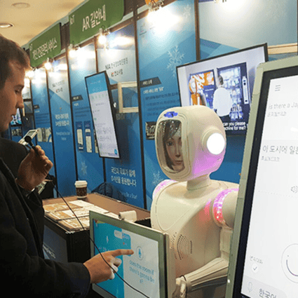 A man tries an artificial intelligence (AI)-converged robot interpreter at Hancom's headquarters in Pangyo, Gyeonggi Province. Photo: Korea Times
