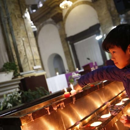 A file picture of a boy lighting candles at a state-approved Catholic church in Beijing. Photo: EPA